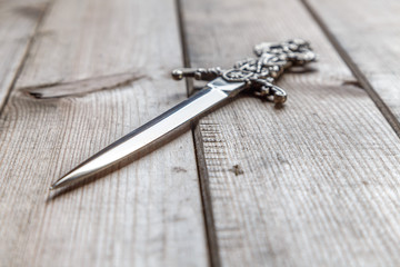 stiletto inlaid with carved arm rests on a wooden table surface