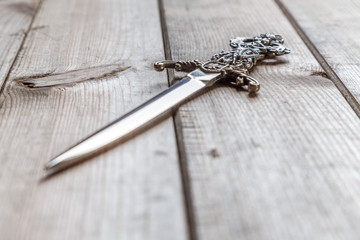 stiletto inlaid with carved arm rests on a wooden table surface