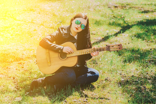 woman playing an acoustic guitar black
