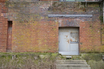 Verrostete Tür in altem Backsteingebäude