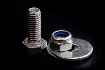 stainless steel bolt with a nut and washers on black