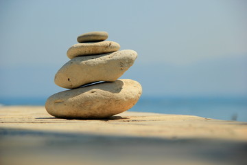 Cairn of four stones on the sea in sunny day. Balance, tranquility and pacification