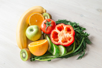 heart made from different fruits and vegetables on light wooden table