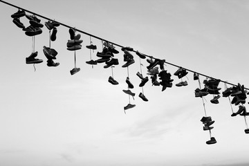 Shoe tossing - a lot of old shoes hang on the rope. Sky background