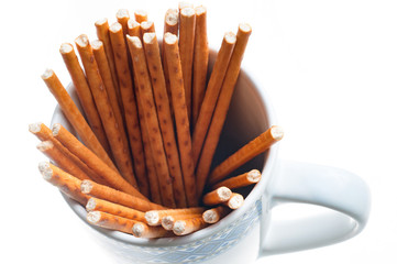 top view pretzel sticks in a cup on white background