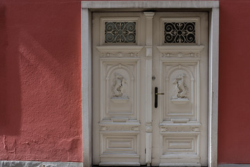 An carved Door in a red Wall