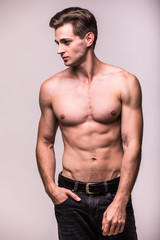 Fototapeta premium Healthy athlete muscular young man on a gray background