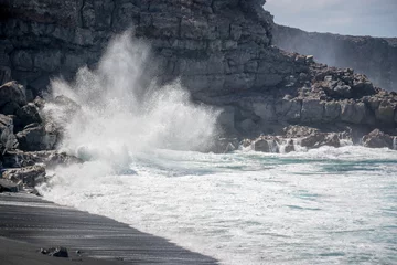 Foto op Aluminium Huge wave crashing on the rocks on Playa del Paso, a black sand beach in Lanzarote, Canary Islands, Spain © Delphotostock