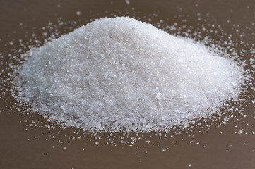 Fototapeta na wymiar Heap of white sugar on a gray background