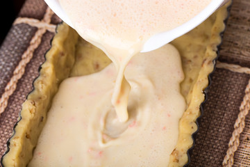 Adding mixed eggs and juice to dough.