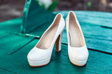 bride's biege shoes on heel on a wooden board tiffany colour