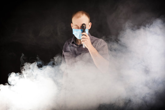 young doctor in a mask in smoke