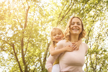 Mother and daughter outdoors in a meadow.