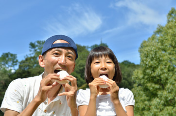 おにぎりを食べる親子