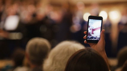 Spectators at concert - people shooting performance on smartphone, music opera