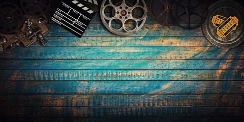 Cinema concept of vintage film reels, clapperboard and projector. - obrazy, fototapety, plakaty