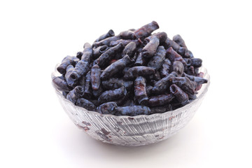 Honeysuckle berries in a bowl on a white background