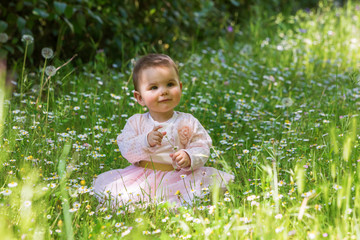 Beautiful baby girl among spring flowers