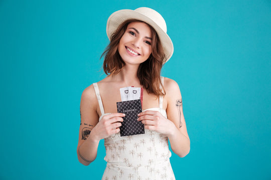 Happy smiling young girl holding passport and travelling tickets