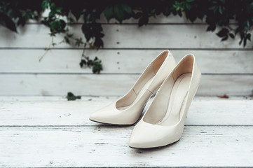 white wedding shoes in the rain on a white wooden table