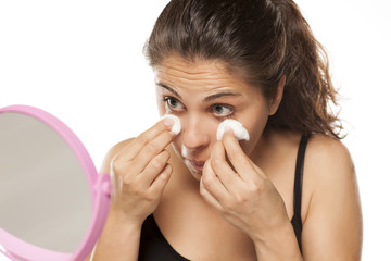 young woman cleans her face using tonic and cotton pads
