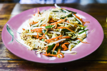 Pad thai on pink on a plate in restaurant, Thailand.