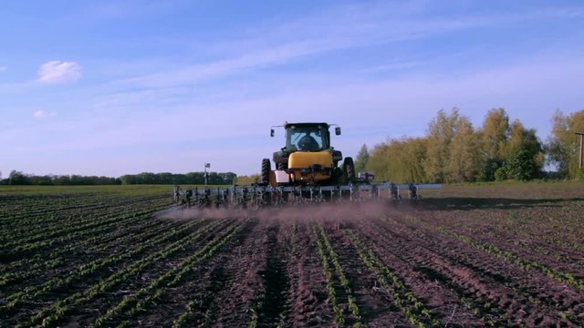 Working tractor and cultivator in the field. Shooting with crane
