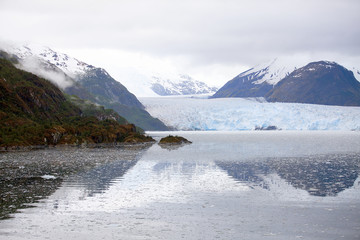 Tierra del Fuego,  landscape of snowy and wooded mountains and ocean