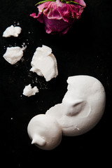 French meringue crumbs on black background with text space