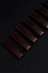 Close-up of dark chocolate bar tiles in a row