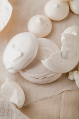 Homemade meringues on ceramic plate and linen fabric