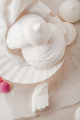 Homemade meringues on ceramic plate and linen fabric