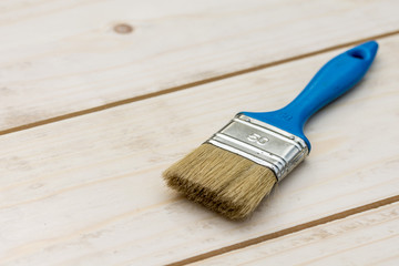 Blue paintbrush on the wooden boards table