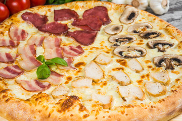 Pizza in four parts, with rosemary and spices on a light wooden background. Italian pizza macro