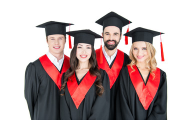 Group of young men and women in graduation caps looking at camera