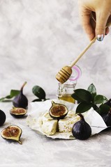 blu cheese, figs and honey on a white marble table, selective focus