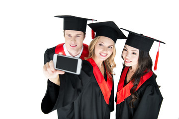 young happy students taking selfie on smartphone isolated on white