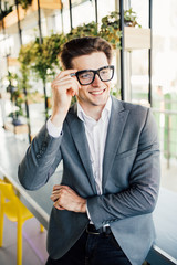 Handsome smiling confident businessman portrait in office