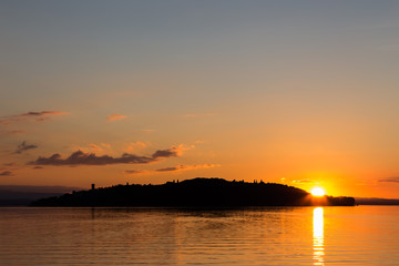Beautiful sunset at the lake, with the sun coming down behind an island