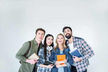 Obraz premium four young students in casual clothes holding books on white