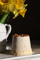 Paskha is a festive dish made in Eastern Orthodox countries.  Curd Easter and yellow daffodils in close up on the dark background