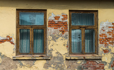 Fototapeta na wymiar Fragment of yellow vintage old brick wall with windows. Textural background. Daugavpils, Latvia.