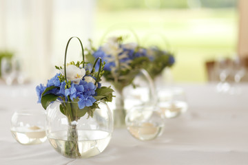 Wedding decoration of blue and white flowers in the round glass vase
