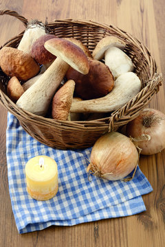 Basket with fresh penny bun  mushrooms on table