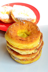 frisch gebackene Ausgezogene Küchle Krapfen auf einem roten Teller