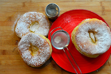 frisch gebackene Ausgezogene Küchle Krapfen auf einem roten Teller