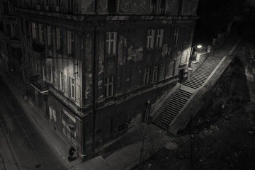 Creepy scene with a lone walker beside an old building on a late evening