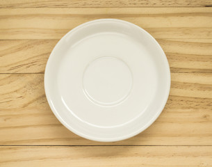 Empty white plate placed on wood.