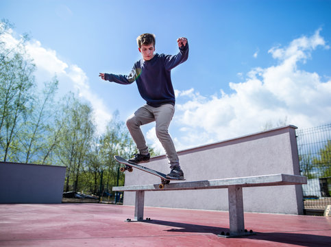 Skater doing croocked grind trick on bench in skatepark