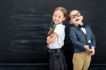 Little girl and boy against blackboard. School concept - 144971722